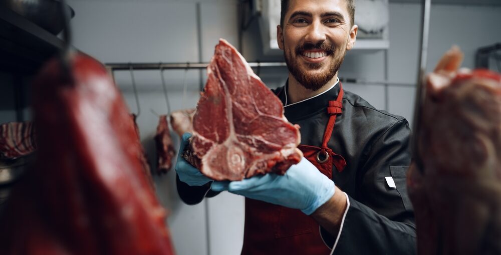 Boucher tenant de la viande